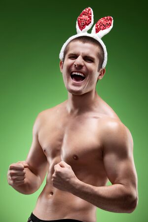 Funny image of muscular male model topless wearing bunny earsの写真素材