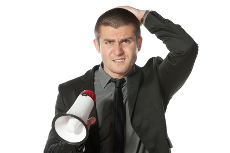 Portrait of angry young business man holding megaphone の写真素材
