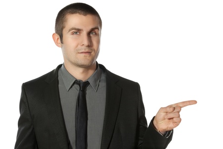 Close up of young business man pointing at copy space over white backgroundの写真素材