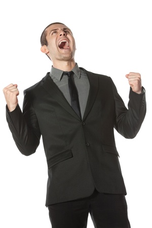 Happy young business man celebrating success shouting upwards, over white backgroundの写真素材