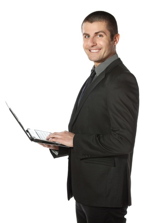Young businessman working on laptop over white backgroundの写真素材