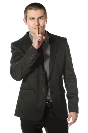 Business man with finger on lips asking for silence over white backgroundの写真素材