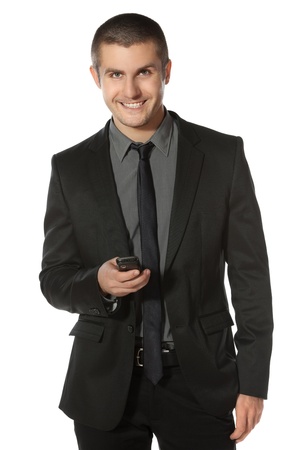 Smiling business man dialing his cell phone over white backgroundの写真素材
