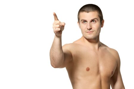 Handsome male model topless pointing at copyspace over white backgroundの写真素材