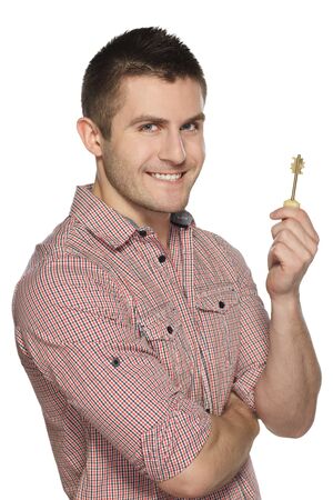 Young man holding house key isolated over white backgroundの写真素材