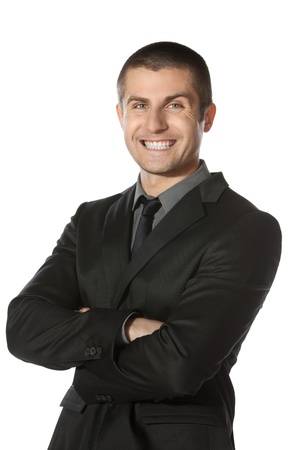 Portrait of young smiling businessman standing with folded hands isolated on white backgroundの写真素材