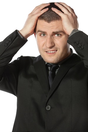 Frustrate young business man holding his head against white backgroundの写真素材