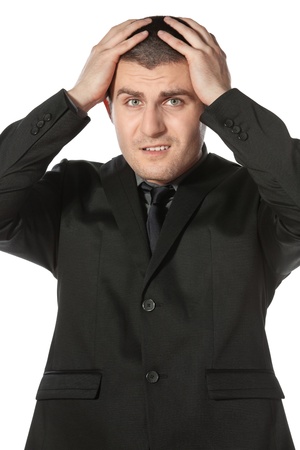 Frustrate young business man holding his head against white backgroundの写真素材