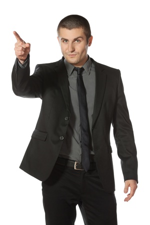 Young business man in suit pointing at copy space over white backgroundの写真素材