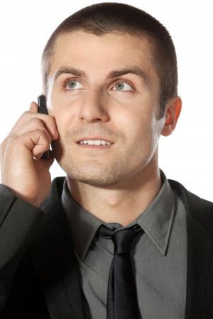Close up portrait of young businessman talking on cell phone looking sideways  isolated on white backgroundの写真素材