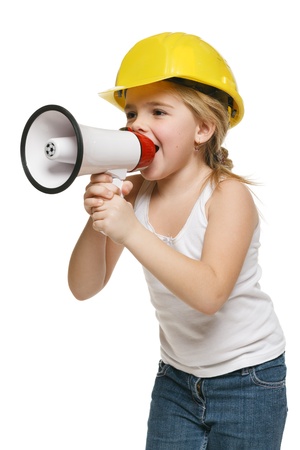 Pretty little girl builder in yellow helmet screaming into the loudspeaker, over white backgroundの写真素材