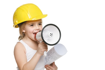 Pretty little girl builder in yellow helmet screaming into the loudspeaker holding drawing in hand, over white backgroundの写真素材