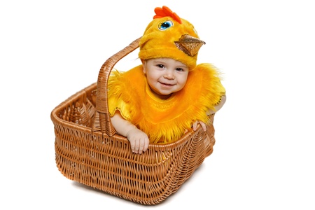 Smiling baby sitting in Easter basket in chicken costume  Easter holiday concept の写真素材