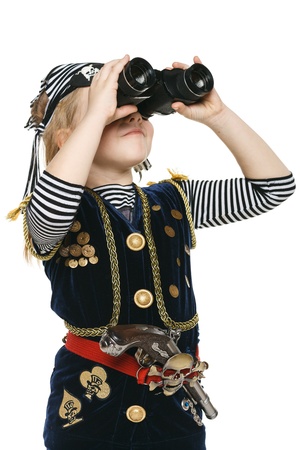 Six years girl wearing costume of pirate looking away through the binoculars, over white backgroundの写真素材