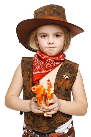Angry little girl wearing cowboy costume holding guns pointing at camera, over white backgroundの写真素材