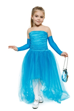 6 years old girl wearing blue ball dress in full length making curtsy, over white backgroundの写真素材