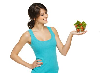 Beautiful woman holding transparent bowl with healthy salad meal, looking at bowl, over white, with copy spaceの写真素材