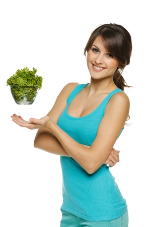 Light food concept  Smiling woman balancing lettuce leaves in transparent bowl, over whiteの写真素材