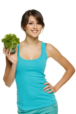 Smiling woman holding lettuce leaves in transparent bowl, over whiteの写真素材