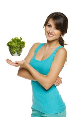 Light food concept  Smiling woman balancing lettuce leaves in transparent bowl, over whiteの写真素材