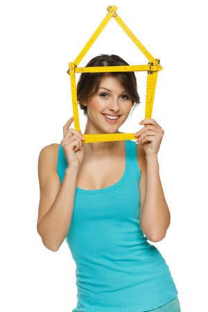 Happy woman looking through the house frame, over white backgroundの写真素材