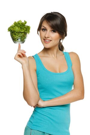 Light food concept  Smiling woman balancing bowl with salad on her finger, over whiteの写真素材