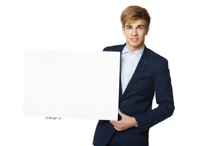 Young handsome man in suit holding blank whiteboard, over white backgroundの写真素材