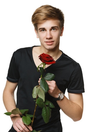 Young hansome man holding the red rose, over white backgroundの写真素材