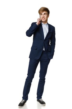 Full length of young business man talking on cellphone, over white backgroundの写真素材