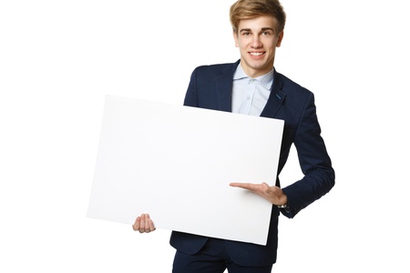 Young handsome man in suit holding blank whiteboard, over white backgroundの写真素材