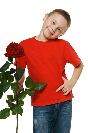 Six years old boy holding the red rose over white backgroundの写真素材