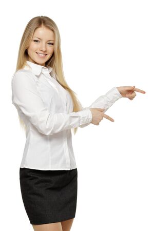 Beautiful blond business woman pointing at copy space over white backgroundの写真素材