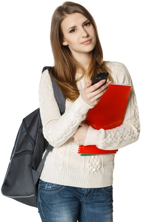 Woman university student with backpack and books sending a sms on cell phone, isolated on white backgroundの写真素材