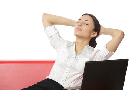Beautiful business woman relaxing with hands behind head and closed eyes on the couch, isolate on whiteの写真素材
