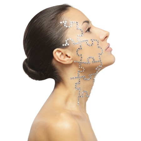 Side view portrait of female with beauty crystal puzzle on her face, isolated on white backgroundの写真素材