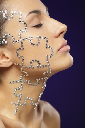 Side view portrait of female with beauty crystal puzzle on her faceの写真素材