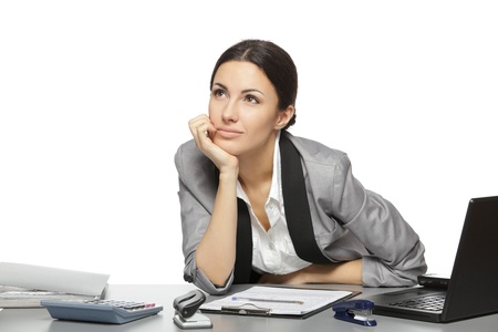 Businesswoman daydreaming at her work place, over white backgroundの写真素材