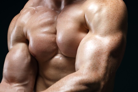 Cropped picture of muscle man posing in studio over dark background