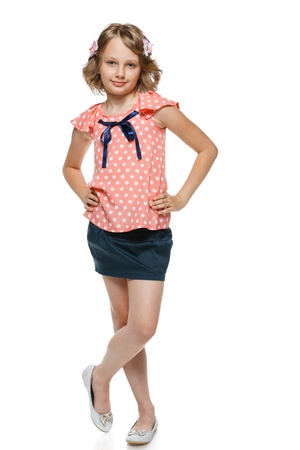Little girl standing wiht hands on hips in full lenght, over white backgroundの写真素材