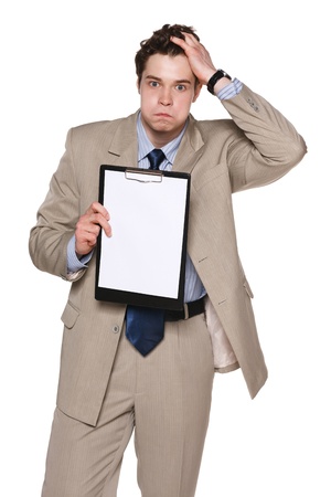 Handsome young business man holding head in frustration showing blank paper, isolated on white backgroundの写真素材