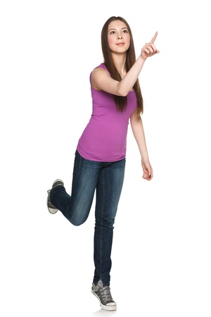 Pressing button young teen girl in full length against white backgroundの写真素材