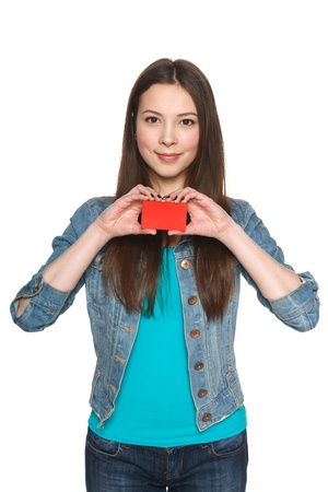 Young teen female showing blank credit card and gesturing thumb up against white backgroundの写真素材