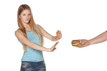 Discontent young female refusing fast food, against white backgroundの写真素材