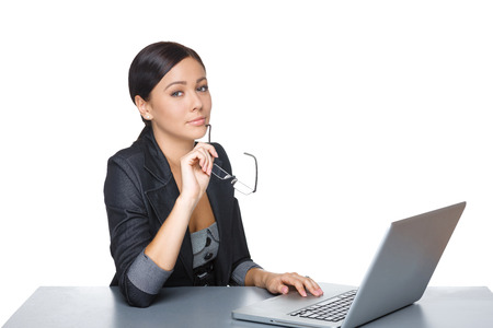 Businesswoman sitting at table with laptop, over white backgorundの写真素材