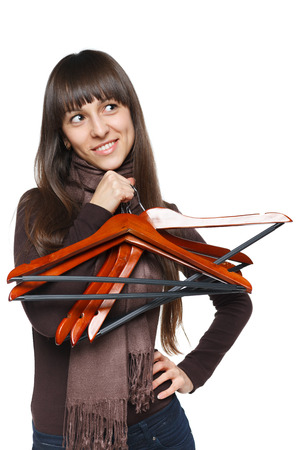 Lovely female holding empty clothing hanger and looking away at blank copy spaceの写真素材