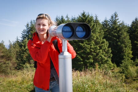 Woman with sightseeing binoculars lookina t cameraの写真素材