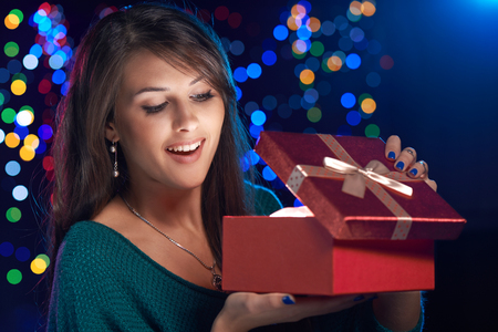 Happy girl opening Christmas box wich is glowing insideの写真素材