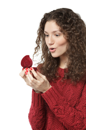 Surprised girl opening jewelry box in shape of heart, over white backgroundの写真素材