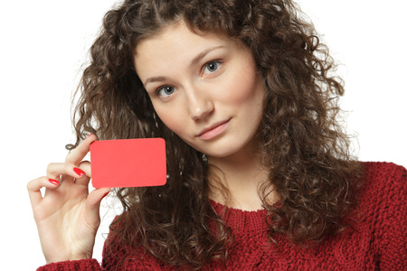 Close-up portrait of young female in sweater holding credit card isolated on white backgroundの写真素材