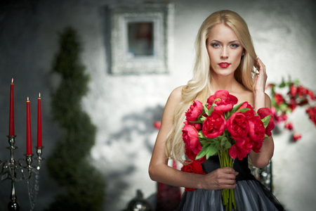 Closeup portrait of fashion model posing with bunch of peoniesの写真素材
